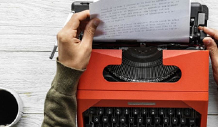 Hands removing paper from typewriter