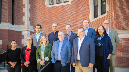 The visiting ESRI team joins Clark Center for Geospatial Analytics Director Hamed Alemohammad, President David Fithian and Provost John Magee on the steps of the Jefferson Academic Center.