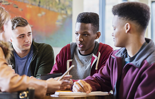 Teen boys talking at lunch table