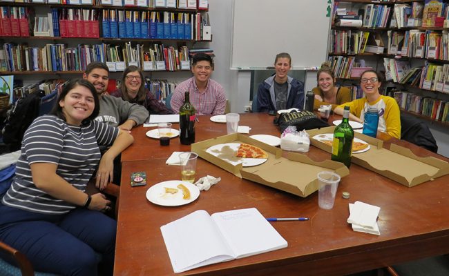 Educators sitting around table with pizza boxes
