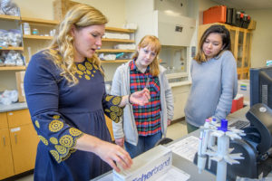 凯伦·弗雷 showing two female students samples in lab