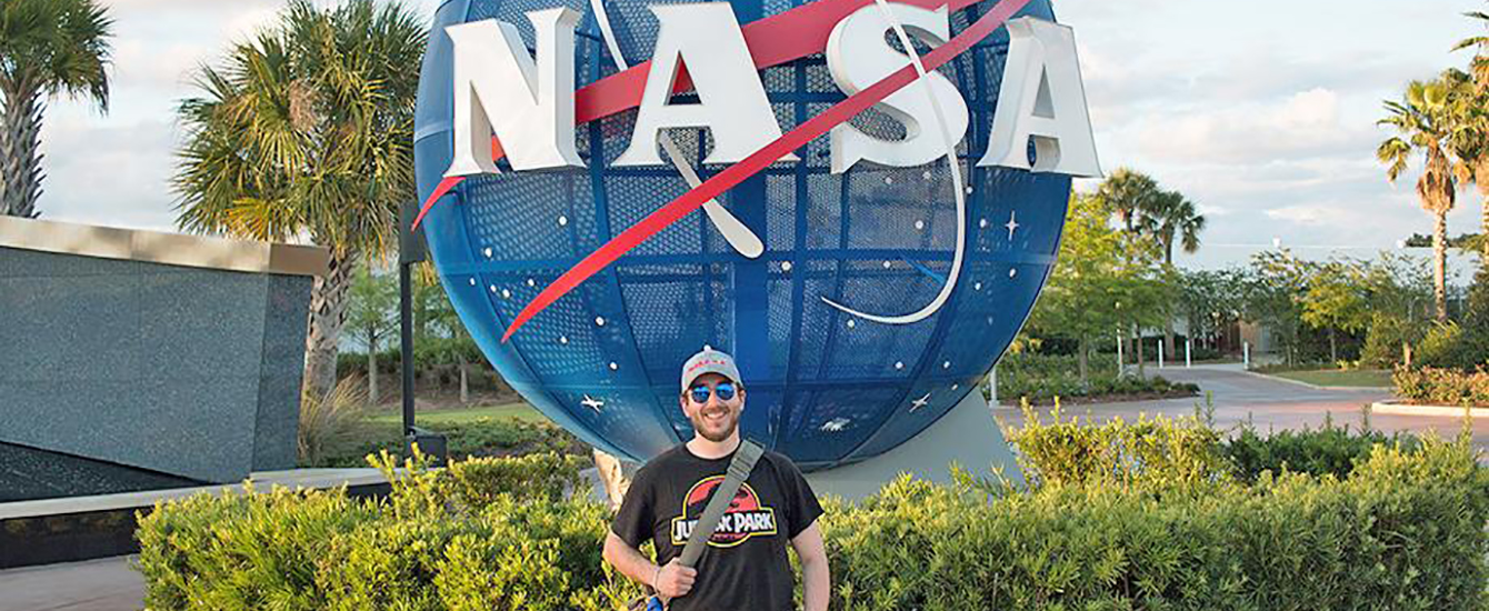 J.P. 伯克，十大平台网赌校友和NASA雇员，站在NASA标志前