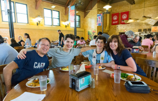 family sitting around dining table in campus center