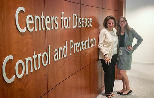 学生和主任站在疾病控制中心办公室的牌子前