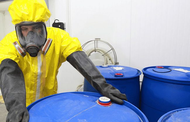 man handling hazardous waste in protective gea