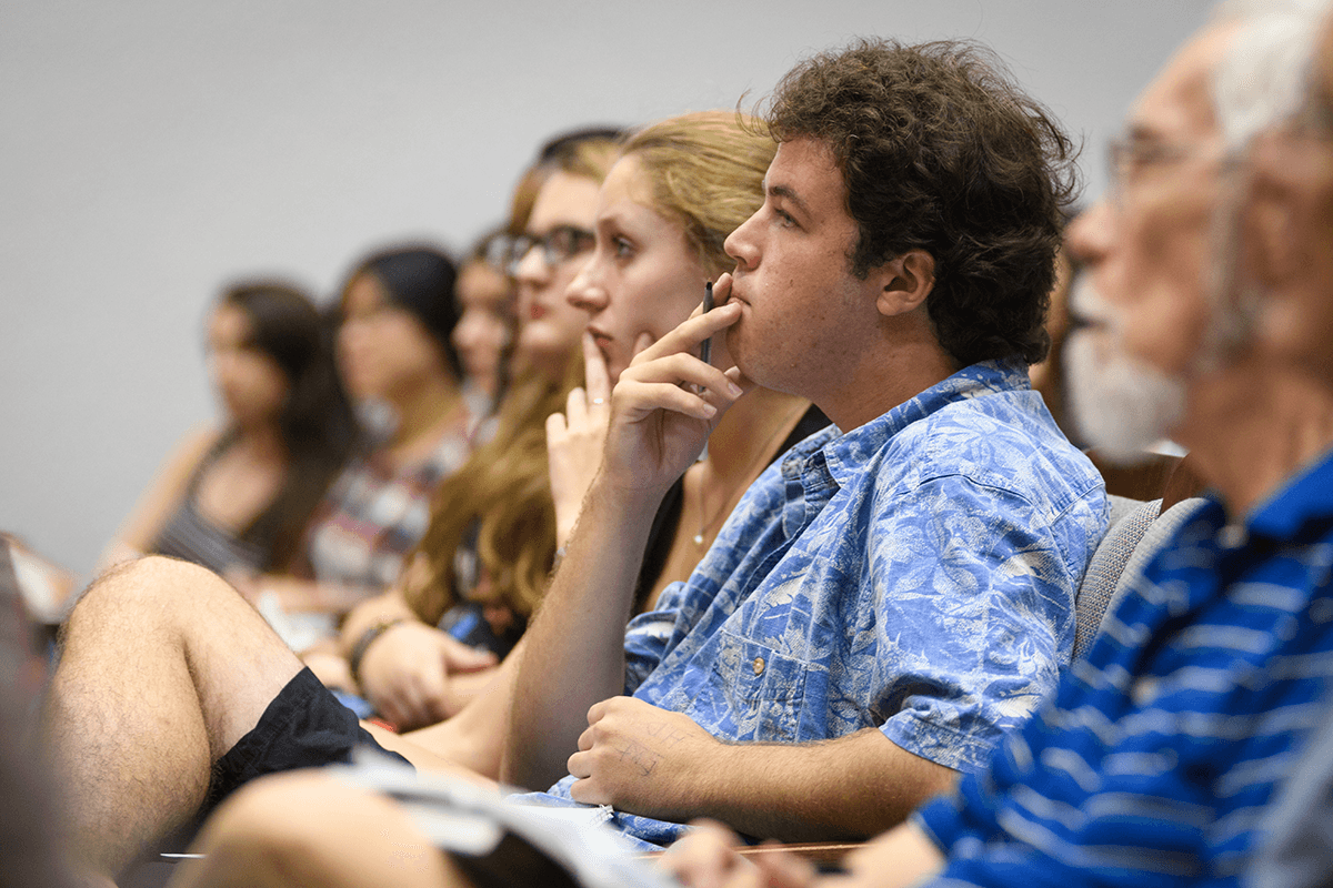 Image of a student sitting in class listening to lecture with a thoughtful look.