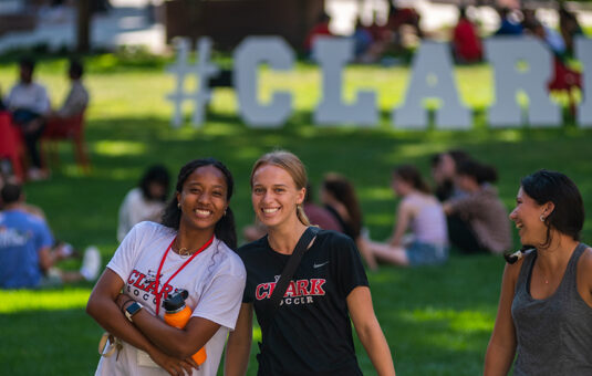 female students sitting in front of campus greens