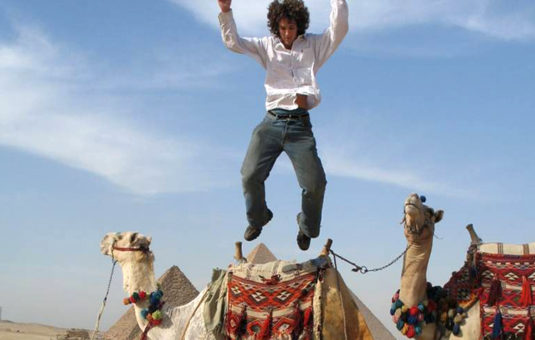 student jumping off camel's back