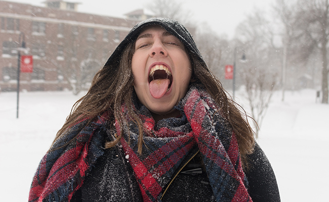 学生在雪中伸出舌头