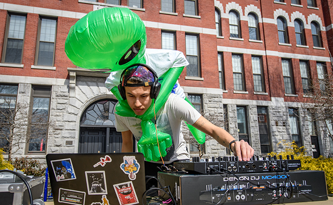 student dj with alien blow up on back