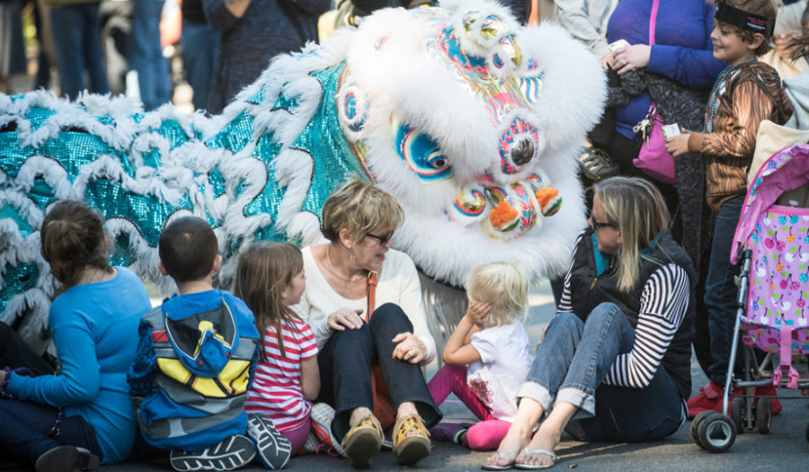 woman on the ground with children and chinese dragon