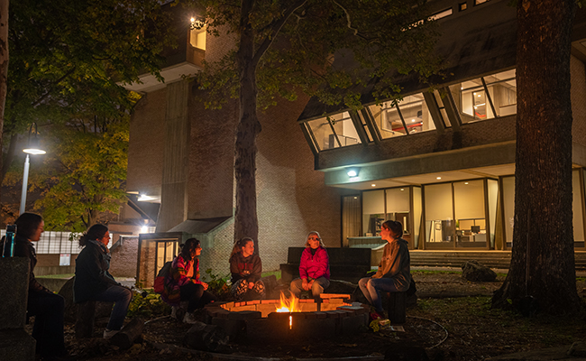 students sitting around fire pit