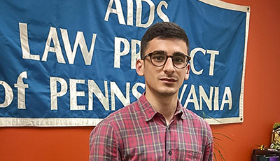 Student standing in front of AIDS sign