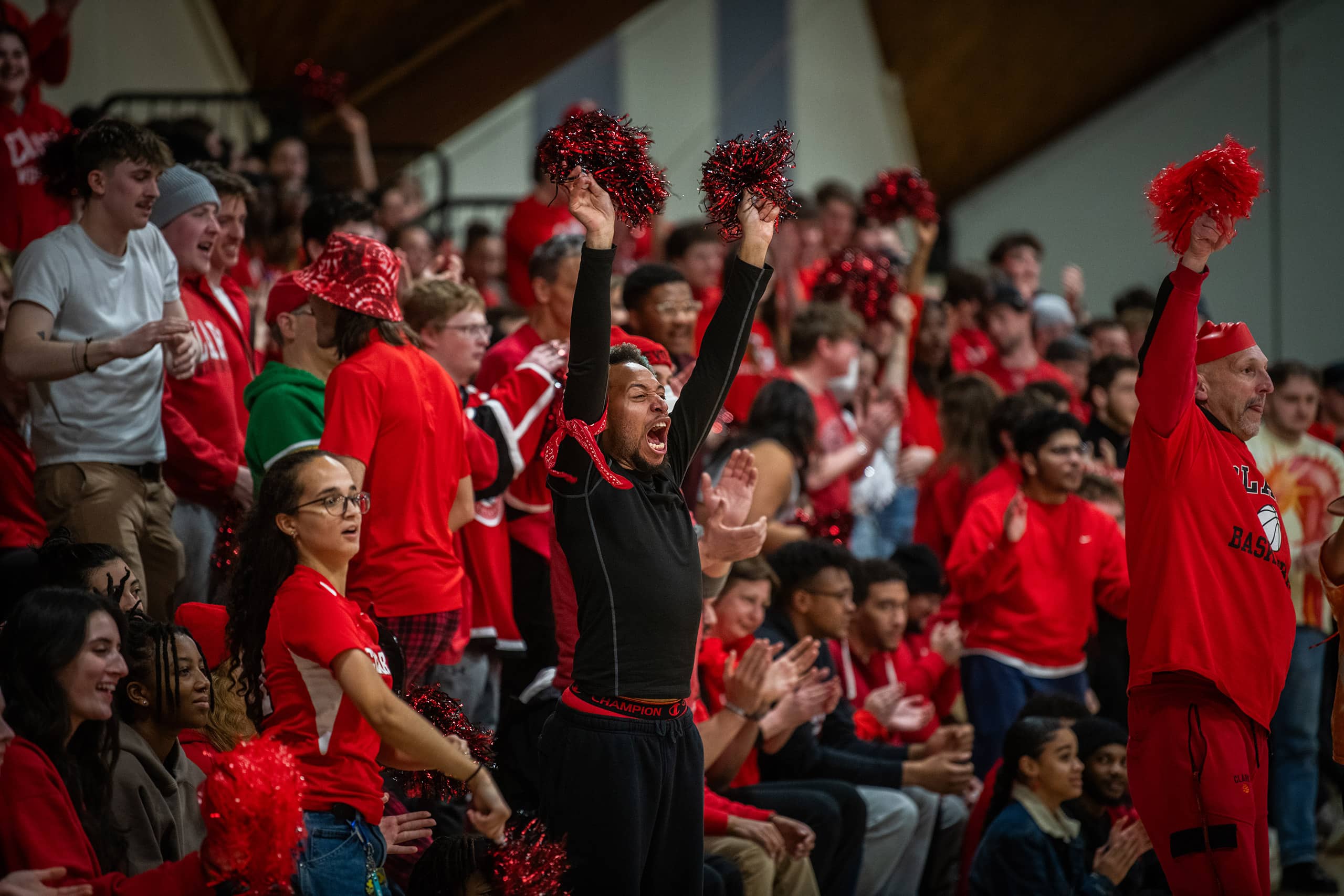 A crowd, dressed in red cheers on the men's basketball team during the season finals