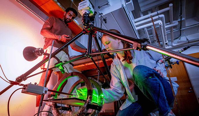 Two students working on a science project in a physics lab