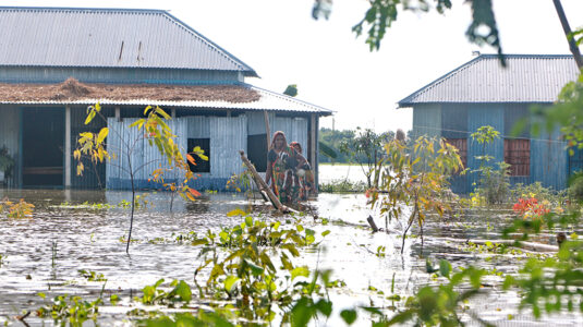 孟加拉国的居民穿越洪水前往地势较高的地方