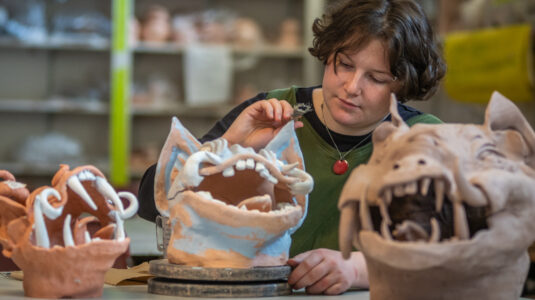 Brynn Keevil '23 created clay gargoyle heads in Clark's craft studio.
