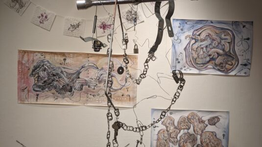 art exhibit with hanging metal piece