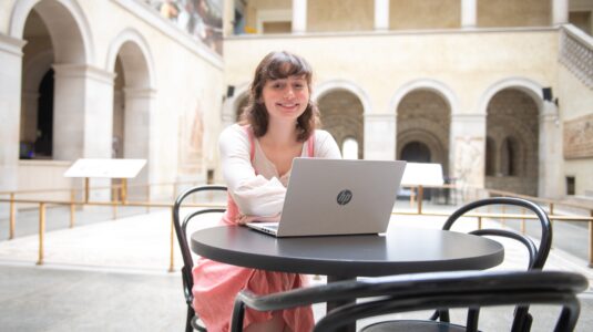 student with laptop in museum