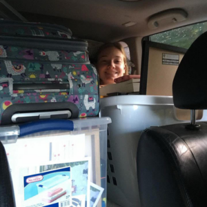 Taylor Laflamme '23, M.S. '24, sitting behind moving boxes in a car