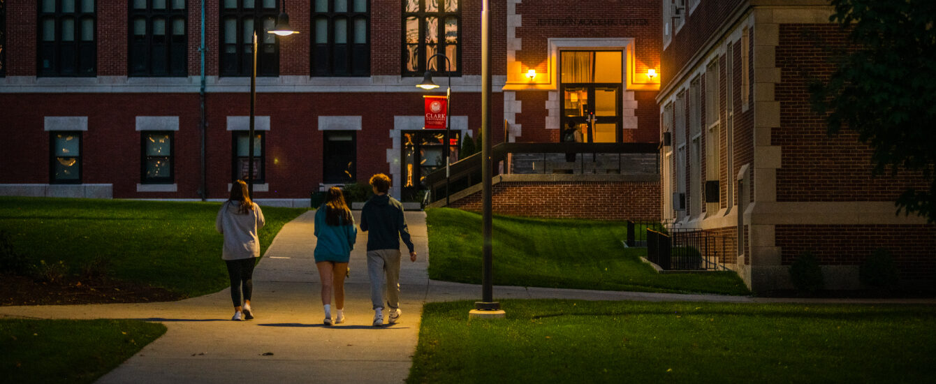 Students walking through Clark campus at night