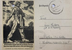Front of postcard featuring image of a German soldier marching.