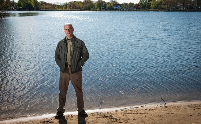 Researcher standing at edge of pond