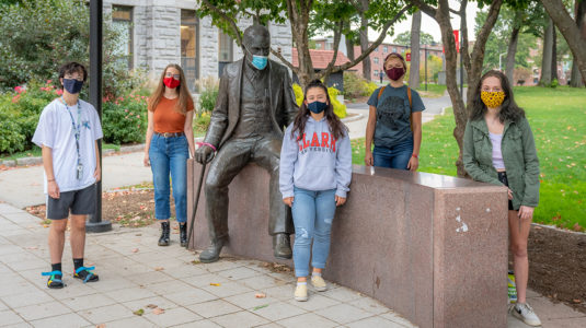 Students in "Pandemic: From Horror to Hope" course stand by the statue of Sigmund Freud on the Clark campus.