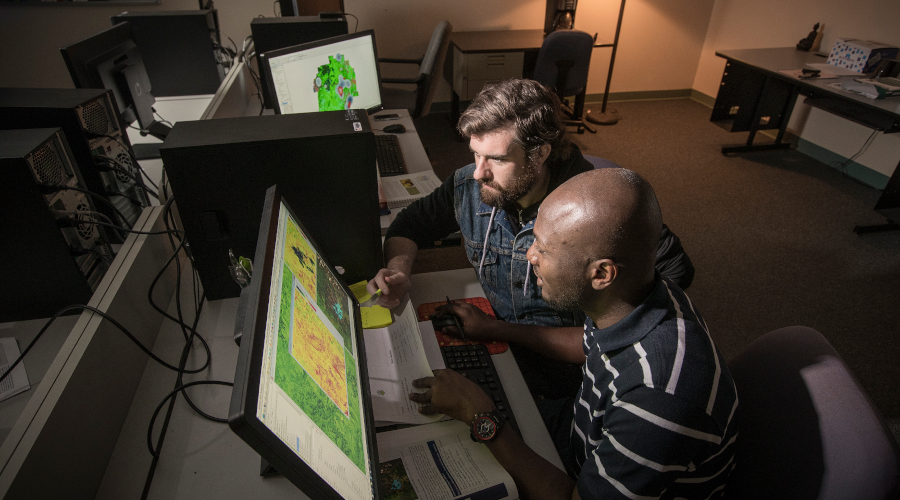 Graduate students working with GIS software