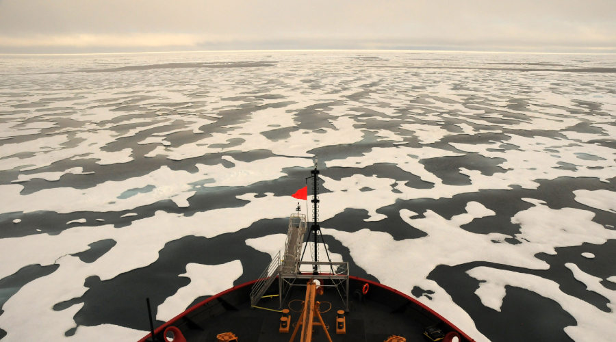 Boat driving through polar sea ice