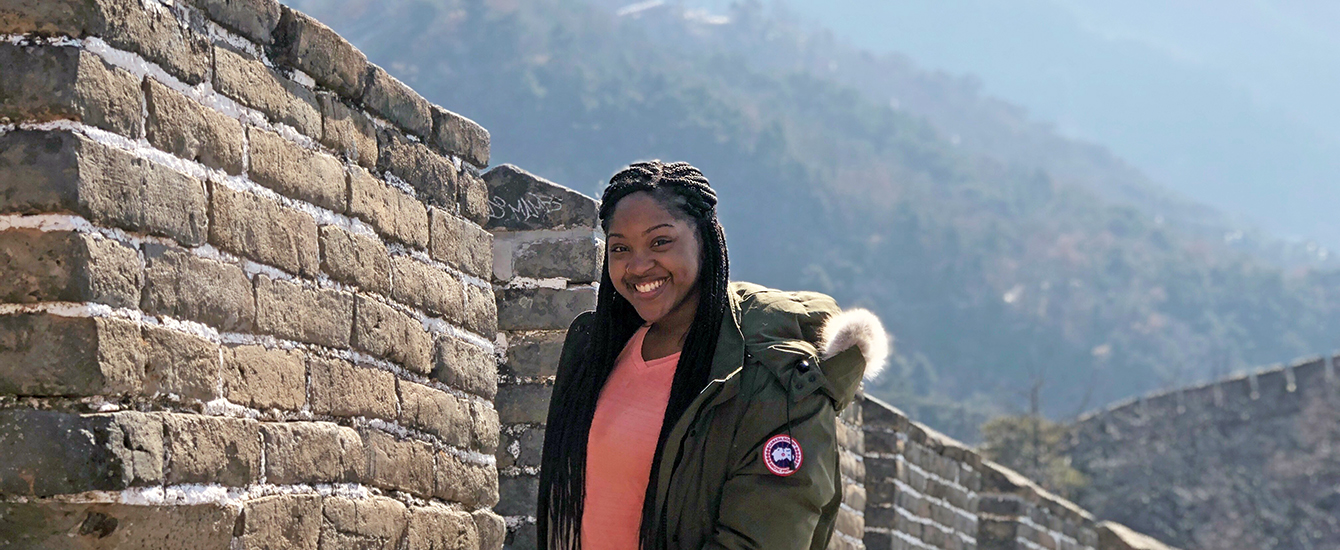 Student standing in front of Great Wall of China