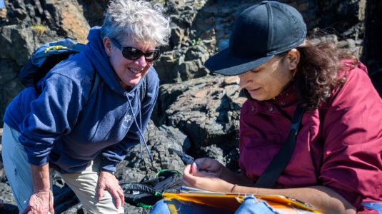 Professor Deb Robertson with a student near the ocean