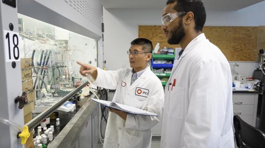 Above, Michael Kebede, right, works with Dr. Jia Wei, Ph.D. ’15, a research scientist at PCI Synthesis.