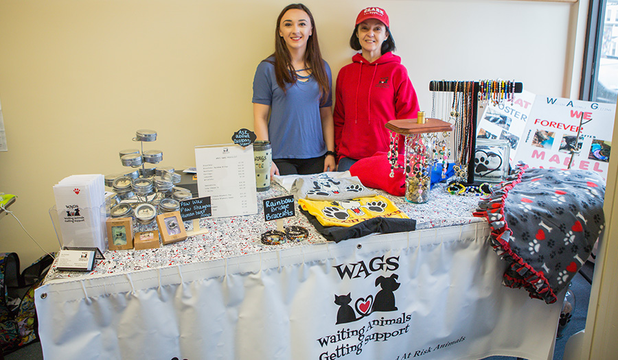 Student and volunteer selling products at table