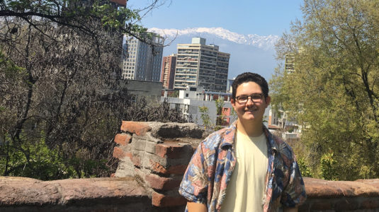 Max DeFaria standing in front of a wall overlooking the city in Chile