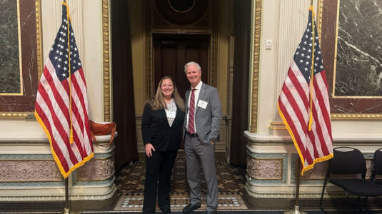 Professors Abby Frazier and Dave White standing inside a White House hallway