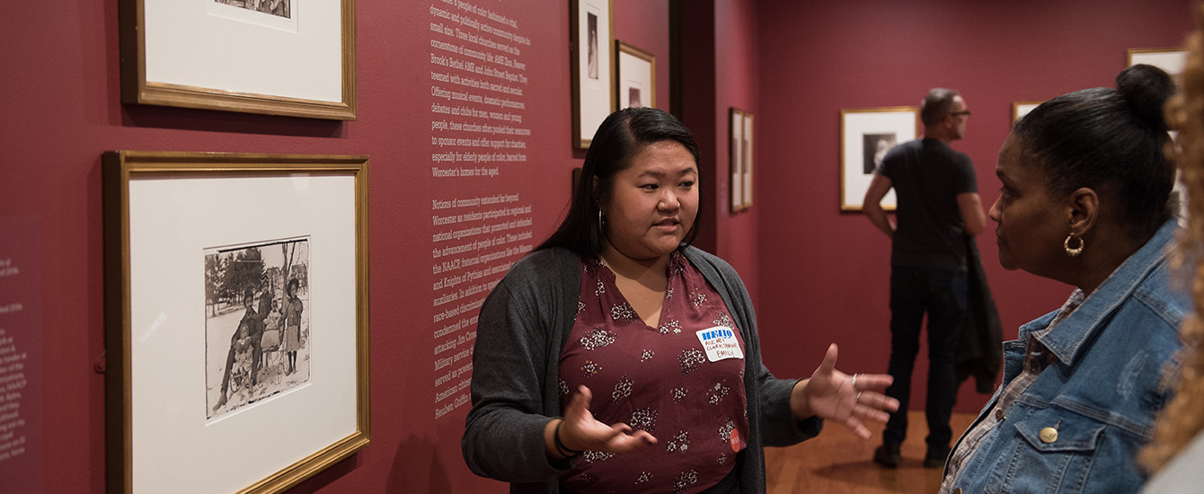Student explaining exhibit to museum visitors