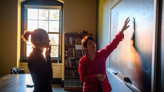 Liana-Shpani works with Physics Professor Barbara Sansone at the blackboard