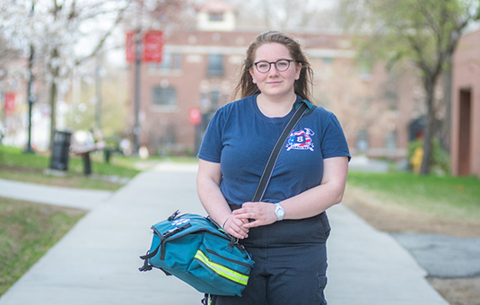 female emt person sitting in front of buildin