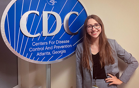 student intern standing in front of CDC sign