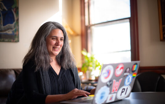 Director of Sustainability and Social Justice Laurie Ross works at a computer