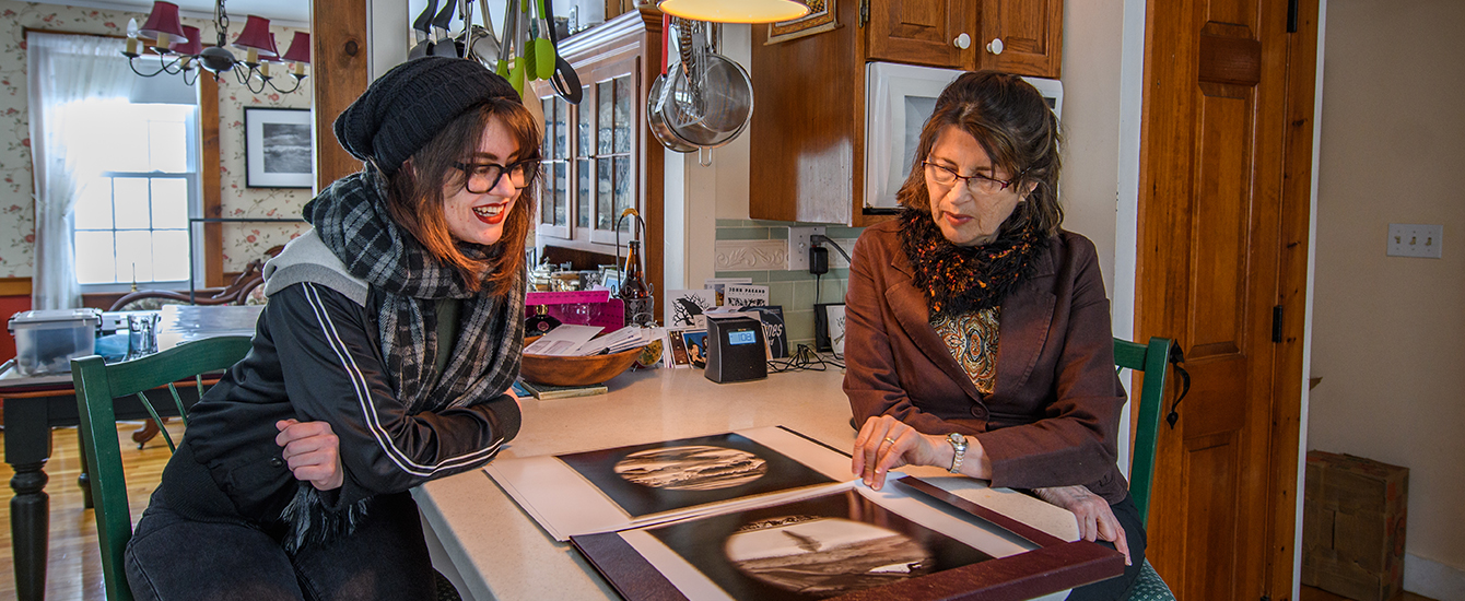 Student working with artist in her kitchen
