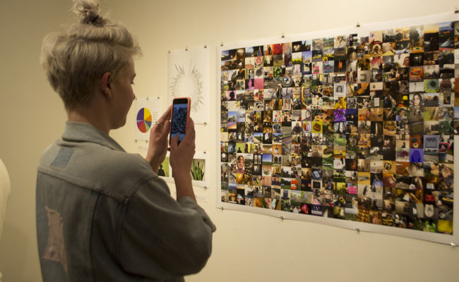 Girl taking picture of photo collage