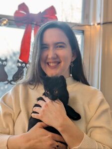 Anna Kathryn smiles, holding an all-black kitten