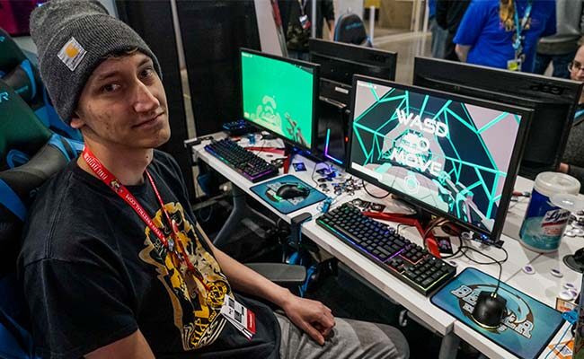 Man in front of computer screen at PAX East 2020