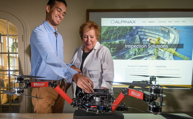 Carriage House - Graduate Admissions and Small Business Development Center administrator looking over drone from student