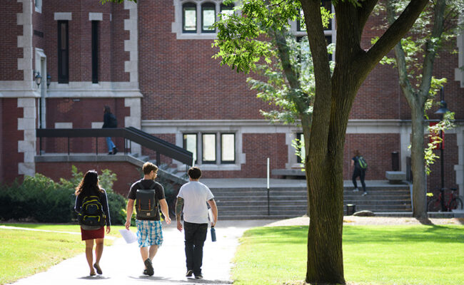 students walking across the greens towards Geography Building