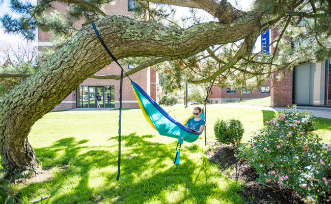 student hanging in hammock in zen garden