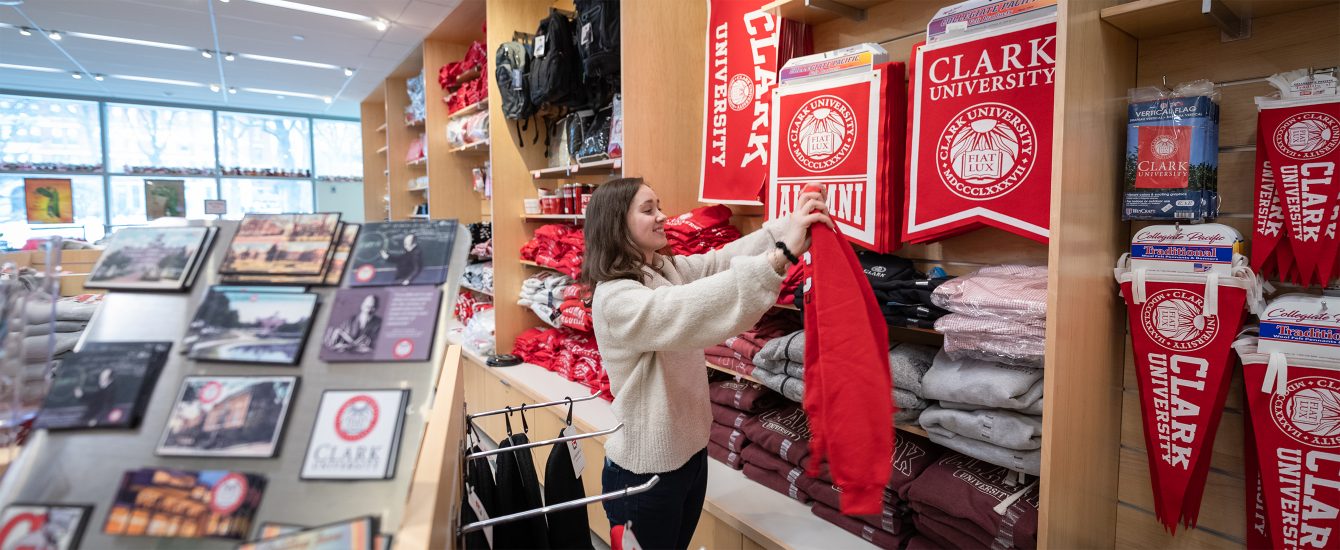 Student holding a Clark University sweater in the campus store
