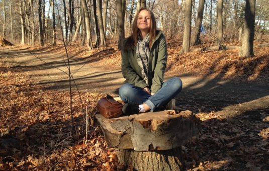 girl sitting on stump
